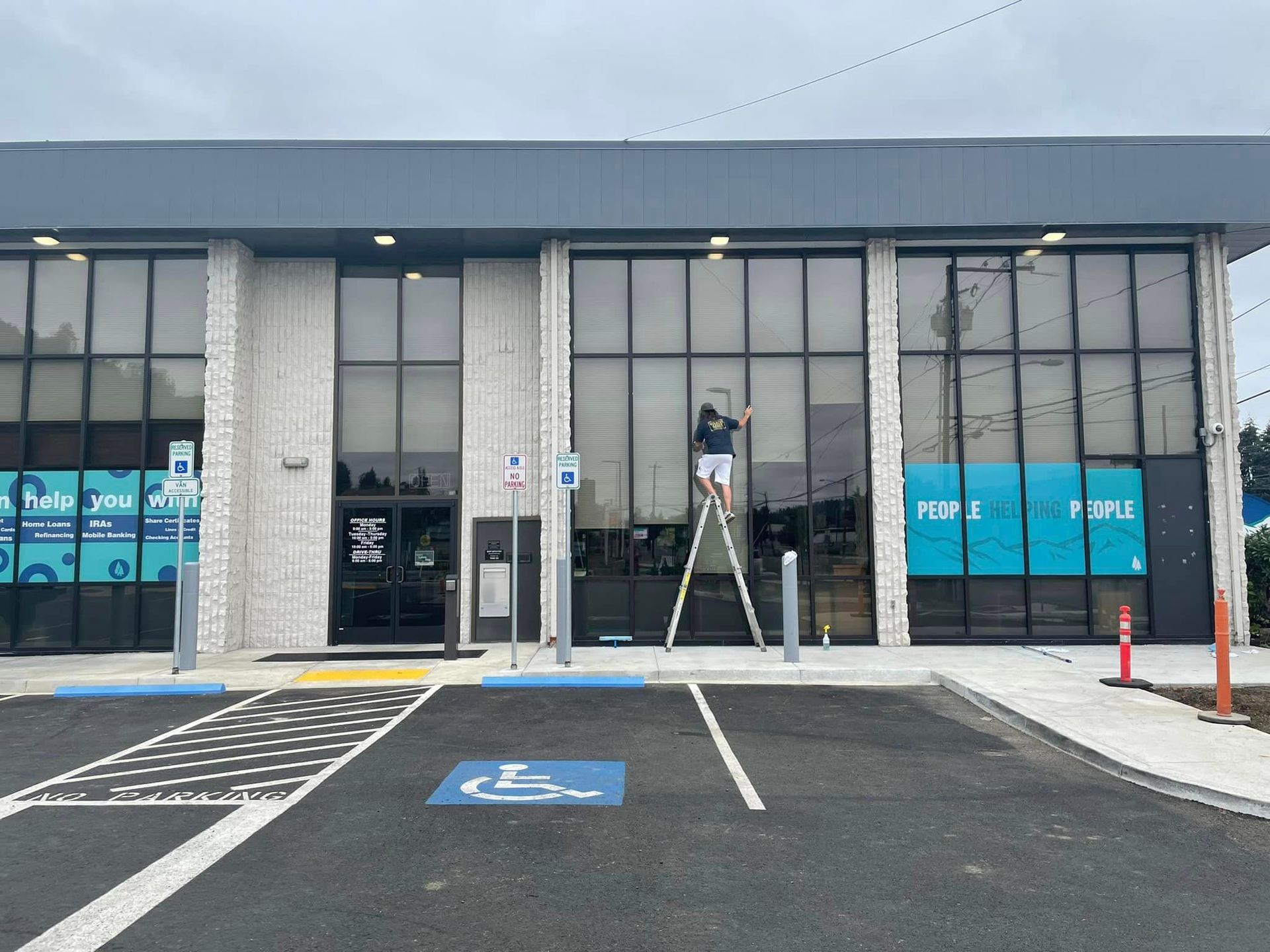 Infinity team member cleaning commercial windows